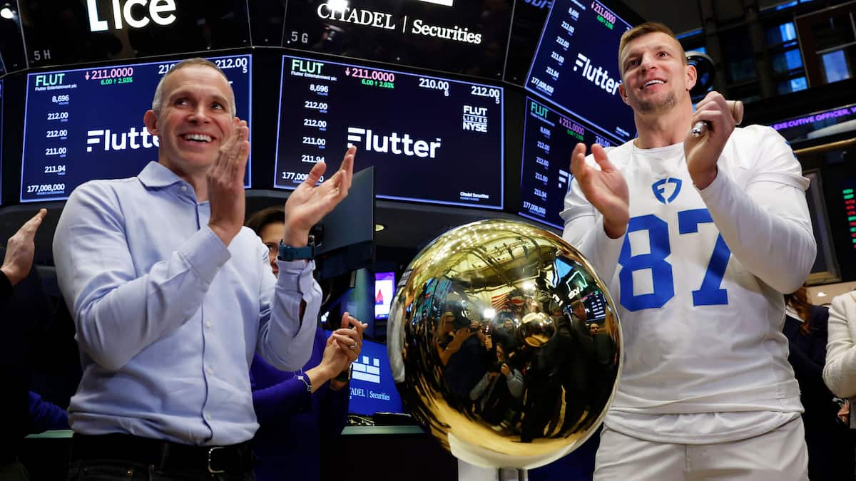 Flutter CEO Peter Jackson and Former NFL player Rob Gronkowski ring the bell on the floor of the New York Stock Exchange